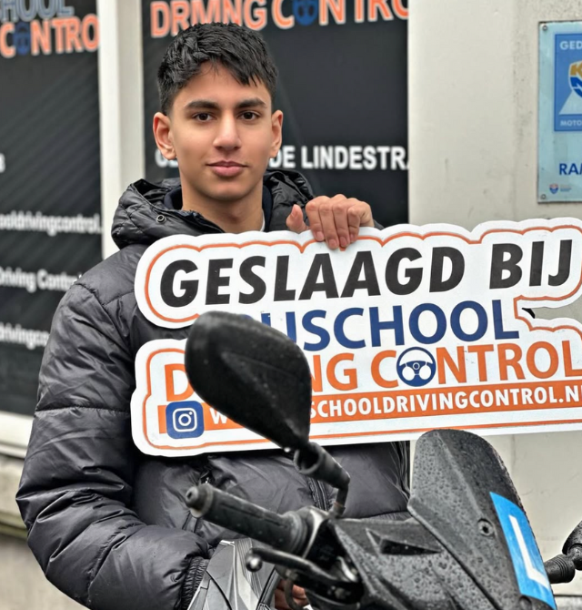 Geslaagde scooterleerling met helm en Geslaagd-bord voor kantoor Rijschool Driving Control Rotterdam